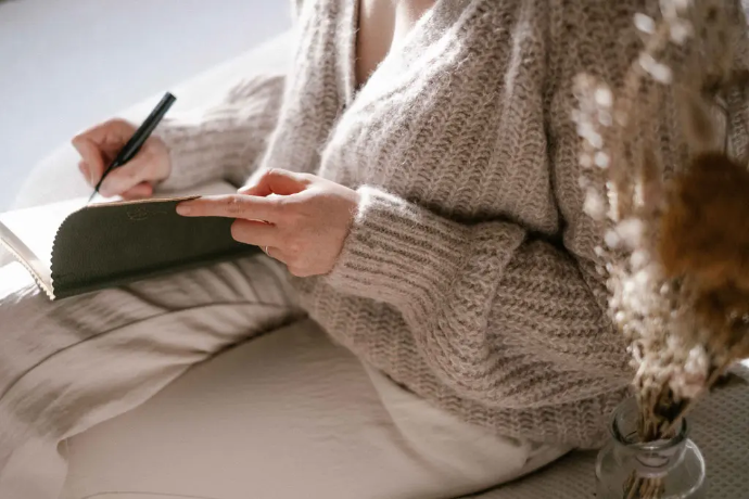 Femme écrivant dans un carnet vert foncé